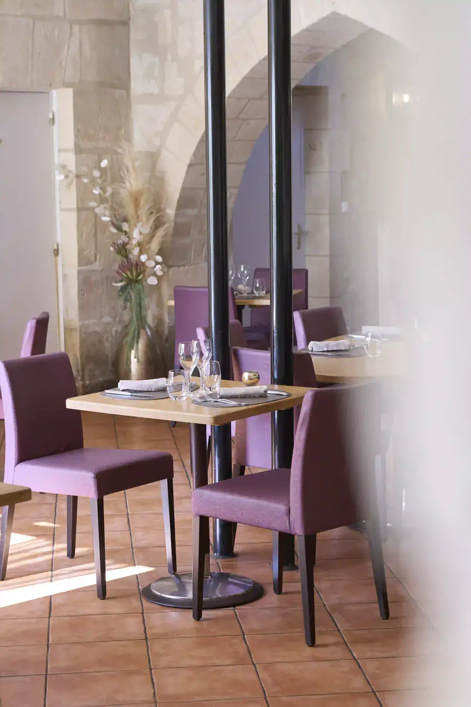 Salle intérieure aux chaises violettes et colonnes, dressée pour une réception privée